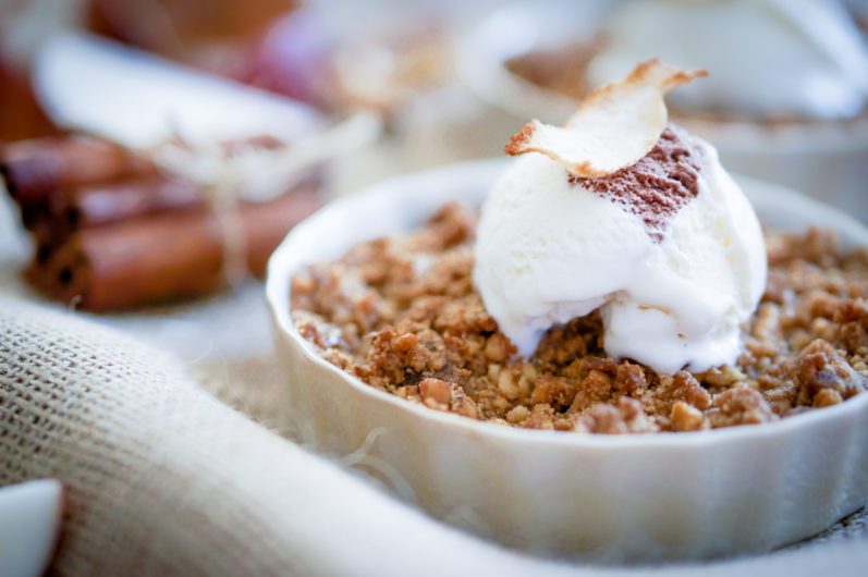 Apple Crumble Dessert With Cinnamon And Vanilla Ice Cream On Wooden Background
