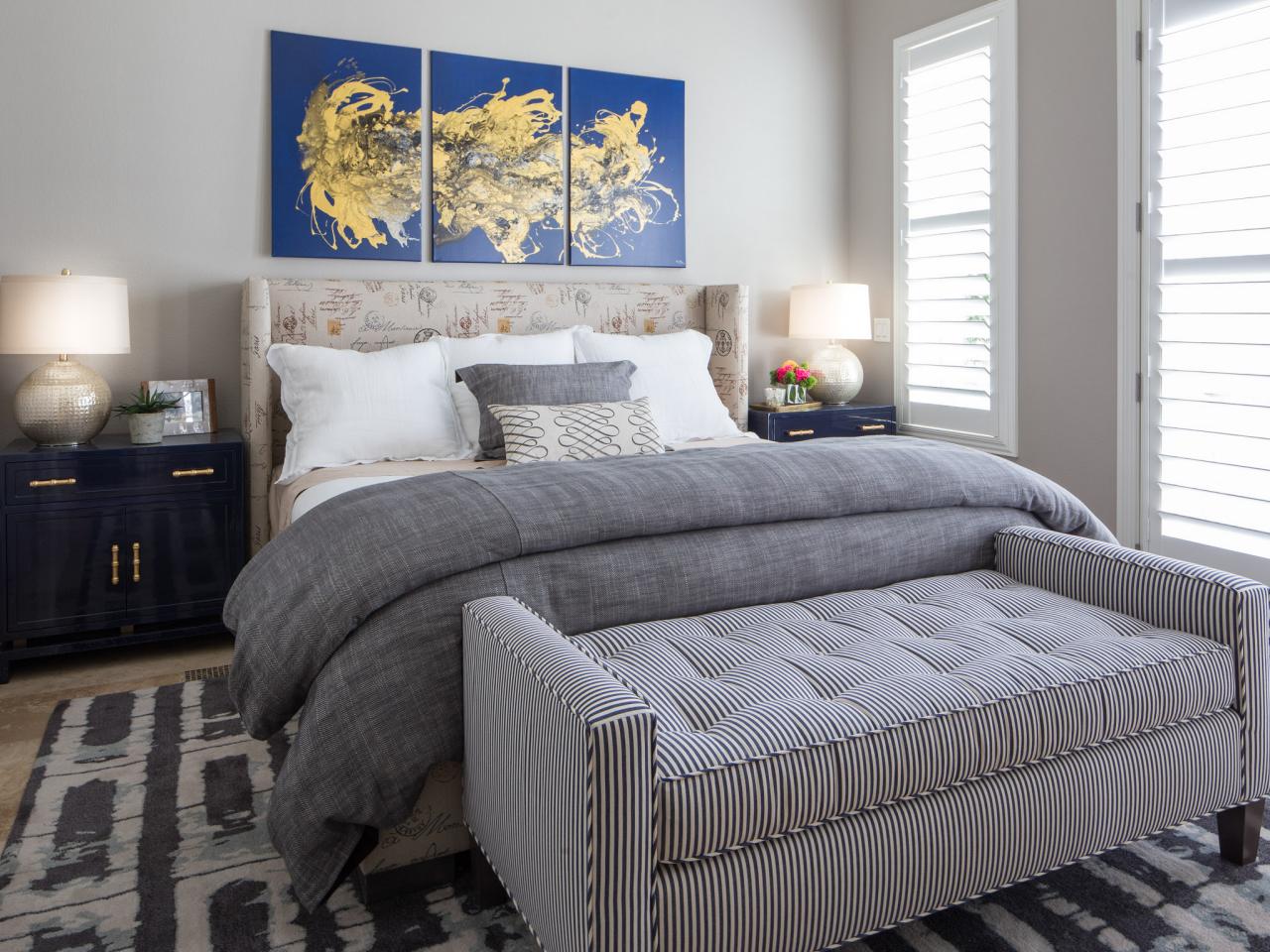 Luxury bedding, grey spread and grey fabric bench at the end of the bed