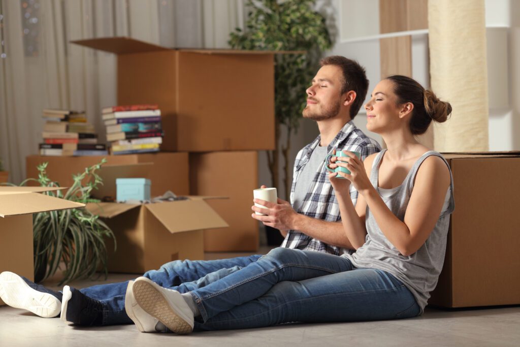 New homebuyers resting against moving boxes, loan for homebuyers