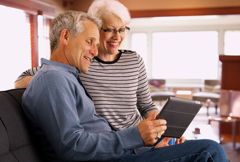 Couple looking at computer and ways to price their home