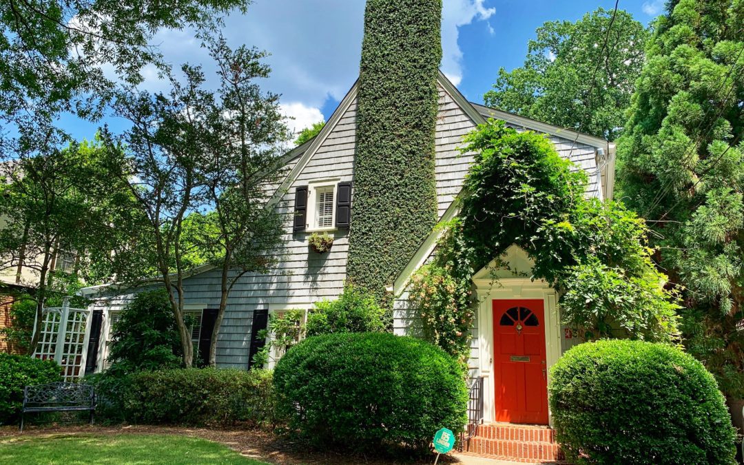 Two story home with red door and chimney, manicured lawn. Home repairs before you sell your home.