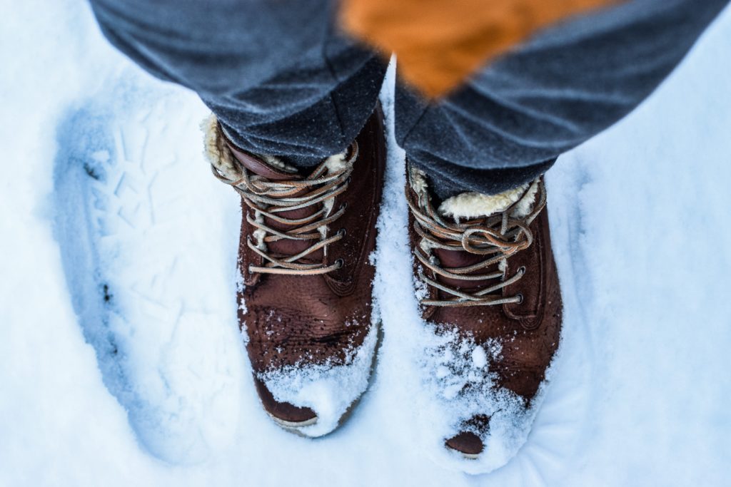 person standing in the snow, part of the article, are heated driveways worth it on the Betty Most Agency blog.